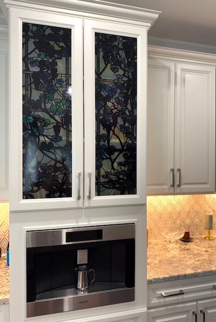 Colorful stained glass cabinet insert in kitchen.