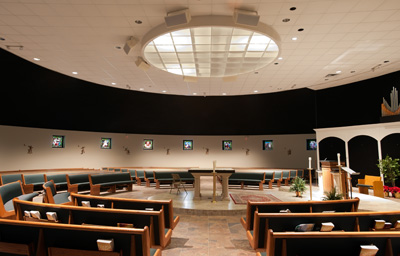 A circular sanctuary surrounded by stained glass windows.