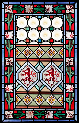 A mix of geometric and floral patterns make up this stained glass panel.