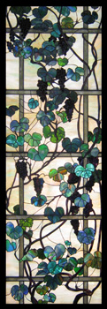 A stained glass panel featuring a trellis and grape vines.