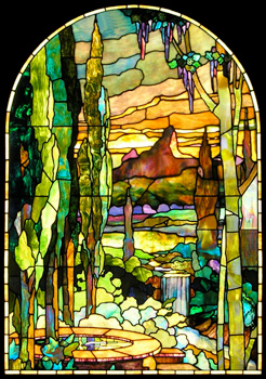 Mountains and trees are colorfully depicted in this Tiffany style stained glass window panel