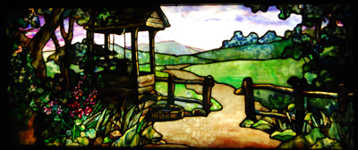 A path leads through a wooden fence beside a well into a pastoral background in this gorgeous stained glass insert, perfect for a library.