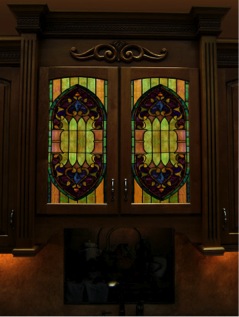 Colorful stained glass panels are pictured in a kitchen cabinet door. Stained glass adds color to your cabinets.