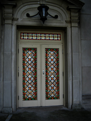 A stained glass door is topped with a beautiful matching transom window. We provide stained glass transom windows that are perfect for your project.